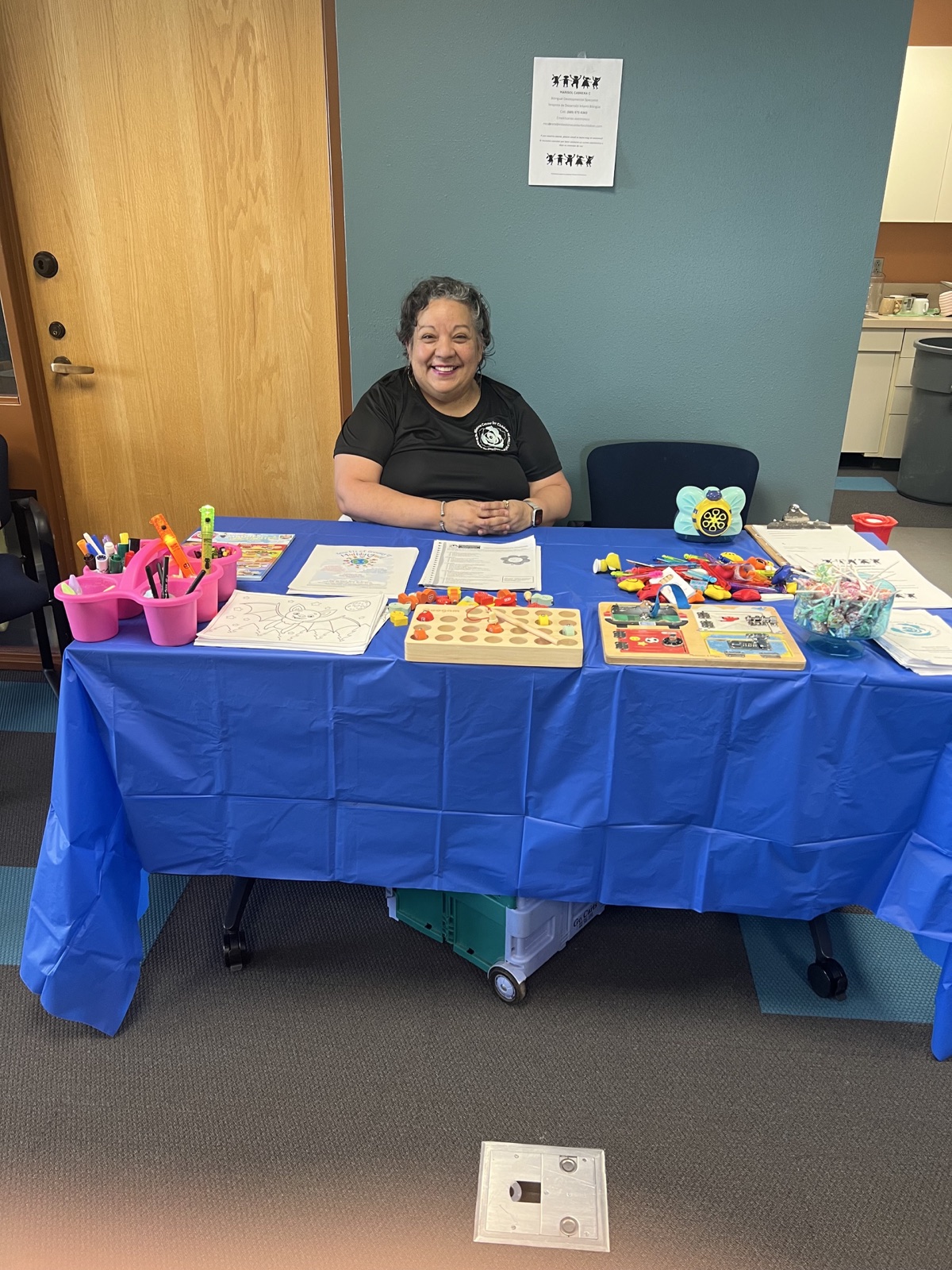 Marisol Cabrera, founder of Milestone Center for Children, seated at a family resource table with learning materials.